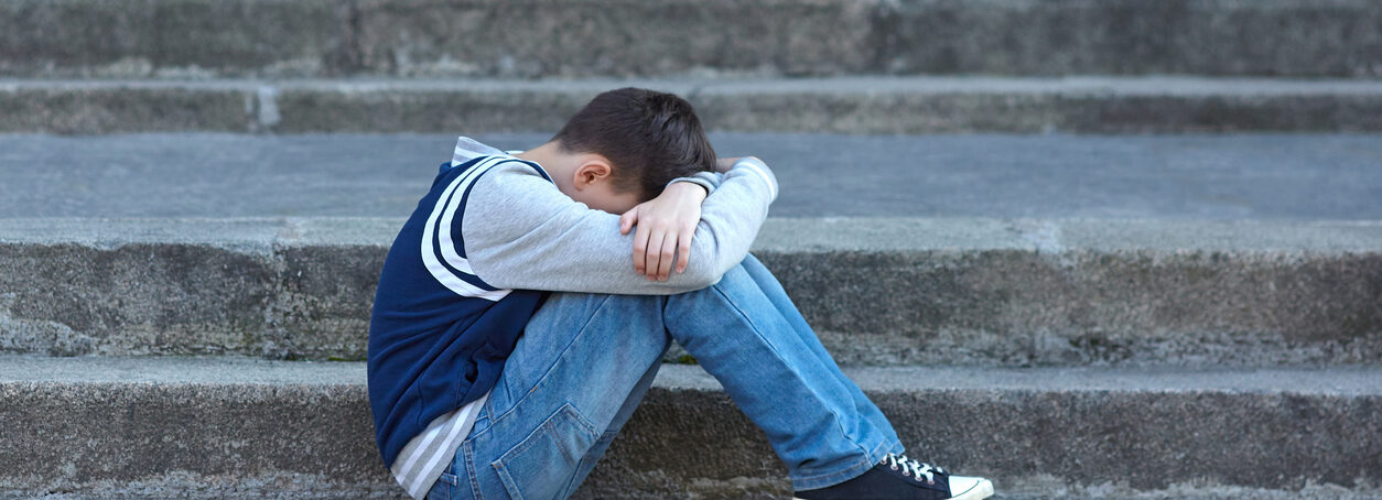 Schoolboy crying in the yard of the school