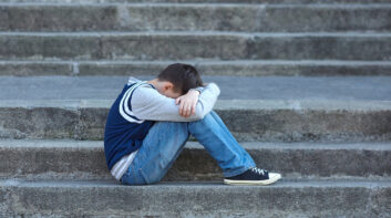 Schoolboy crying in the yard of the school