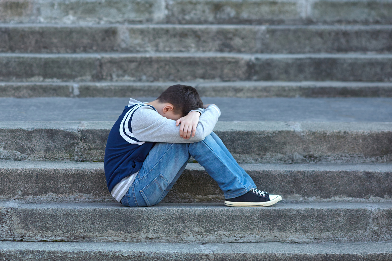 Schoolboy crying in the yard of the school