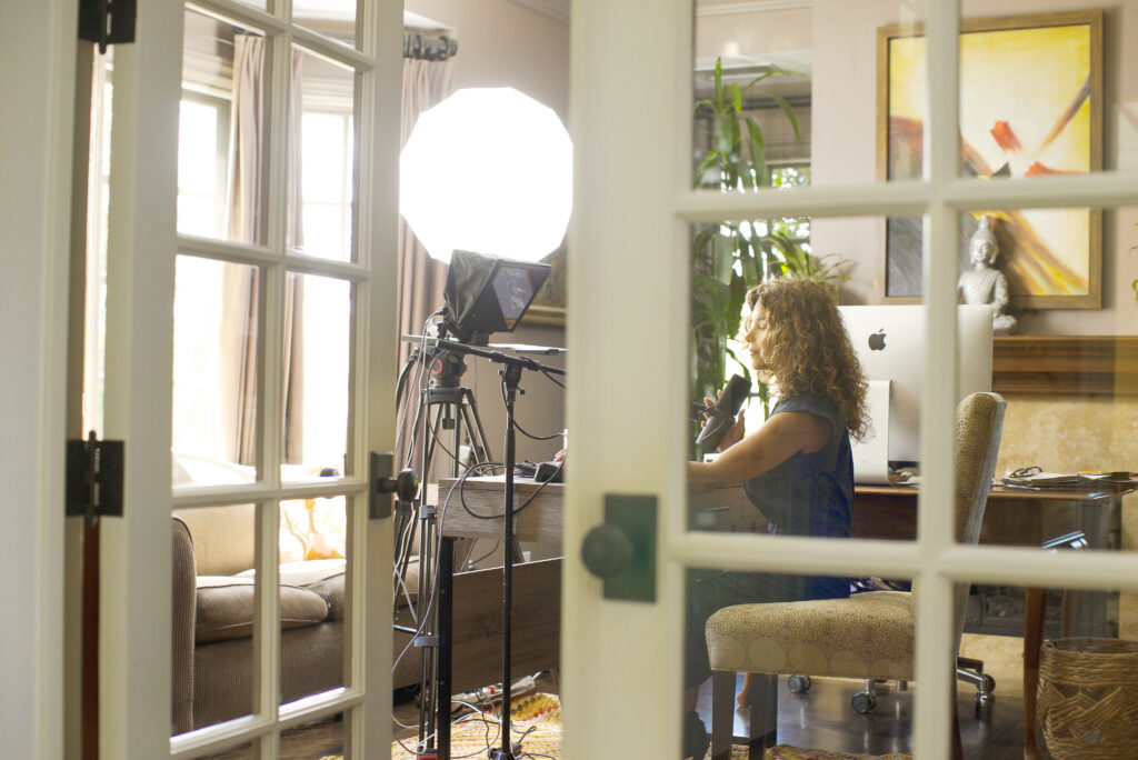 Carla Ondrasik sitting at her desk and recording an interview