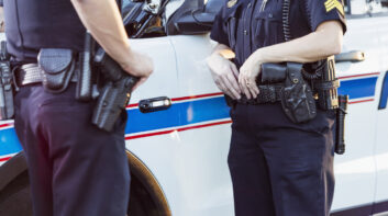 Policewoman and partner next to squad car