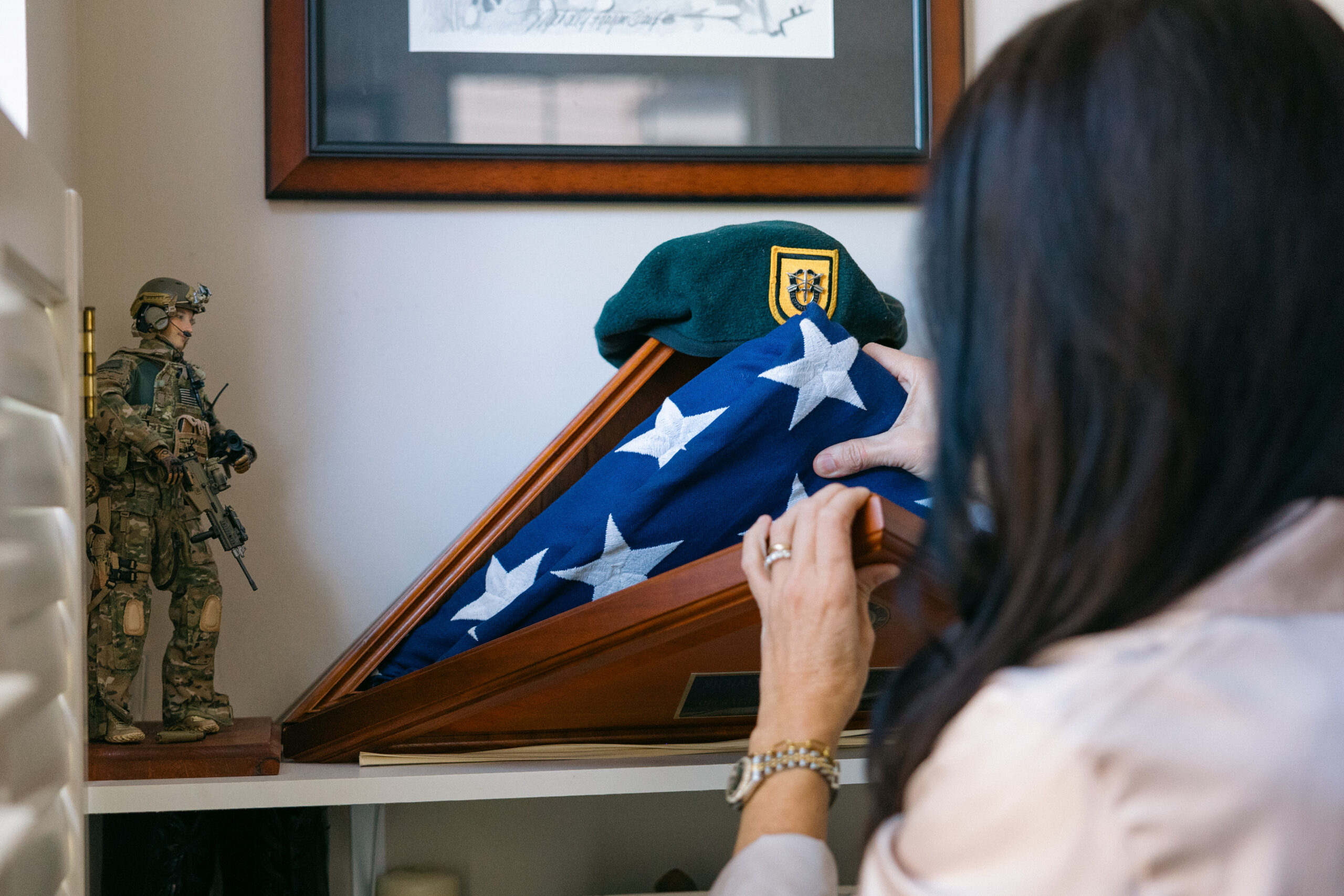 Krista Simpson Anderson observes her husband's service flag, encased in a triangular memorial box with his Green Beret resting above it