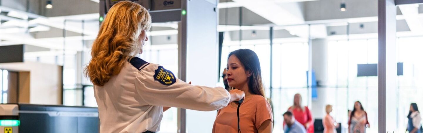 Woman being scanned by a TSA agent