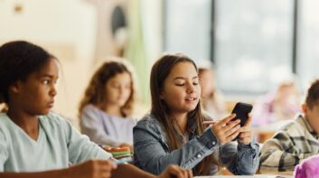 Young girl using her cell phone in school