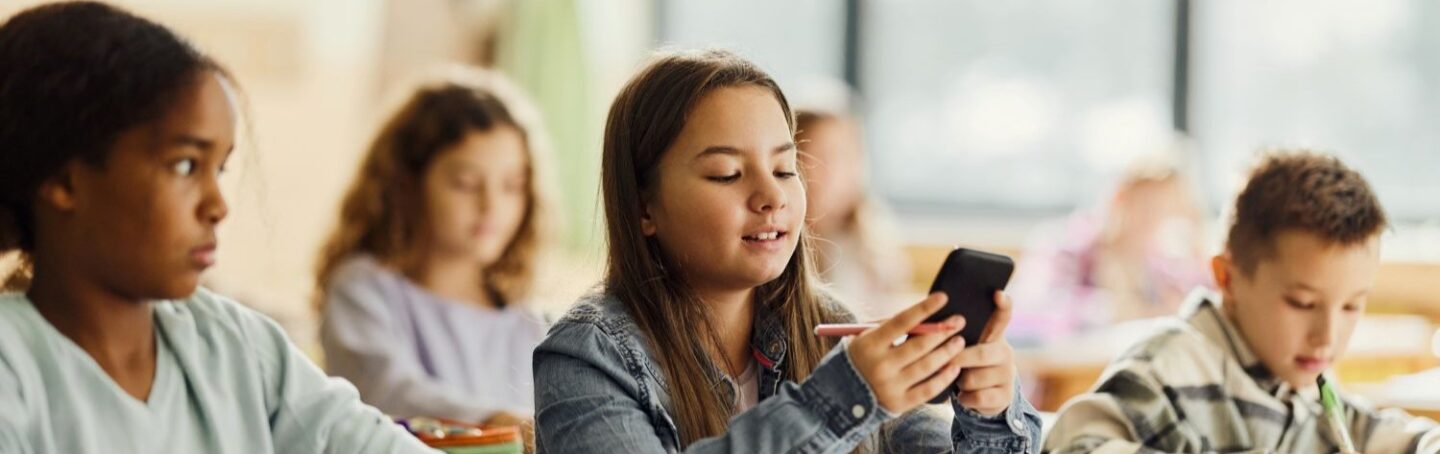 Young girl using her cell phone in school