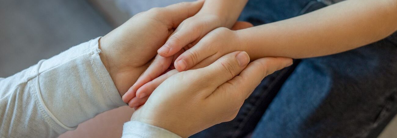 Mother holding a young child's hands