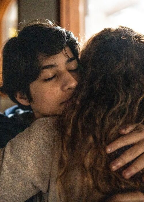 Mother hugging and protecting her teenage son mobile crop