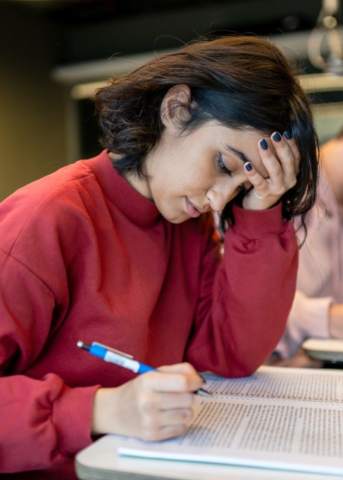 Stressed teenage girl studying