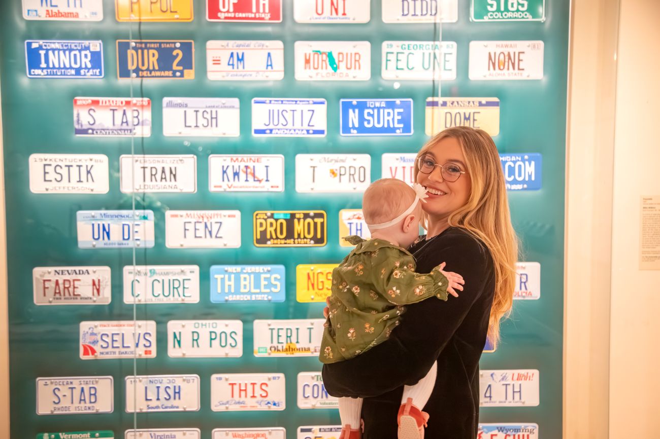 Isabel Brown and Isla in front of U.S. license plates