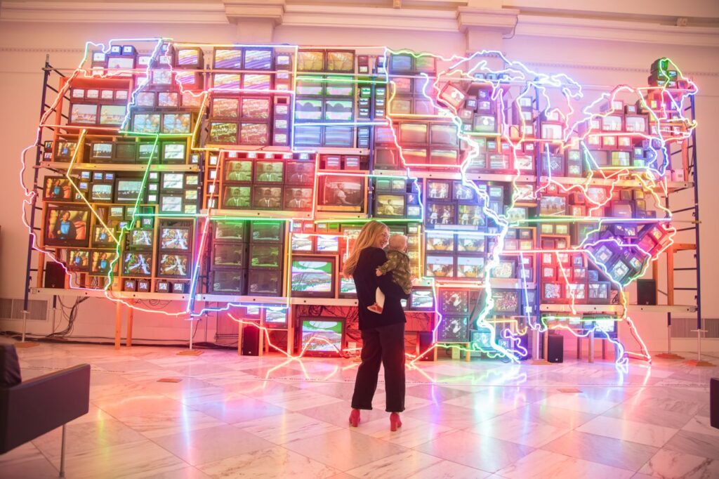 Isabel Brown in front of a light-up art installation of America
