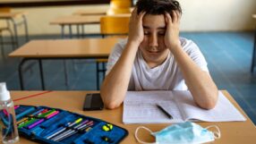 Student frustrated staring at a COVID mask