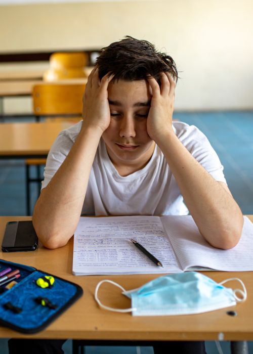Student frustrated staring at a COVID mask mobile crop