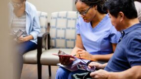 Health care worker talking with patient in waiting room
