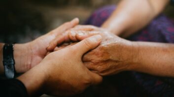 Family caregiver holding the hands of a senior citizen