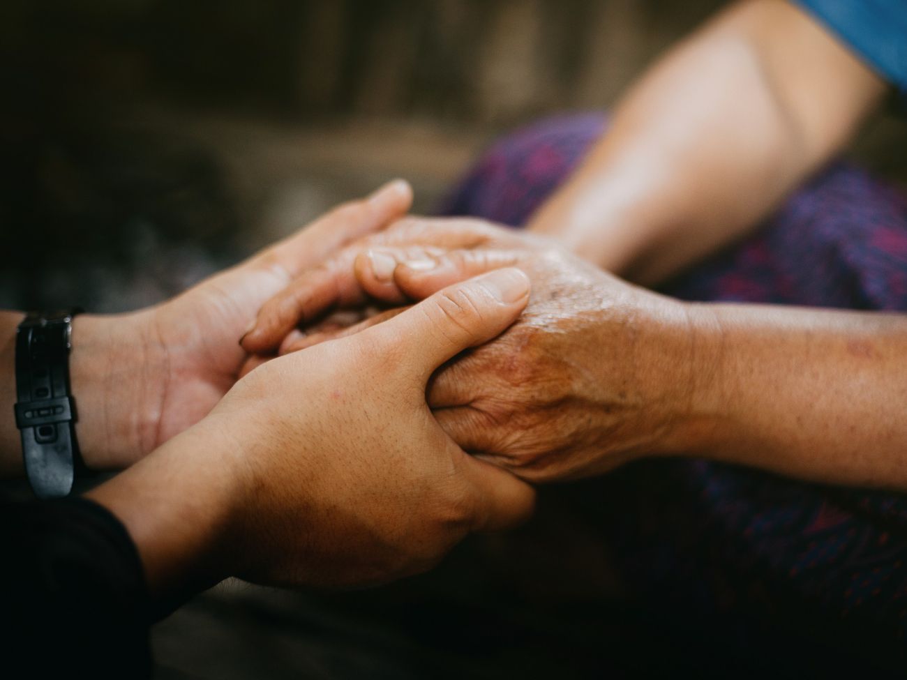 Family caregiver holding the hands of a senior citizen