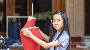 Young female entrepreneur measuring on a dress form