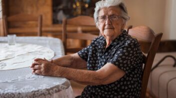 Elderly woman sitting at her kitchen table