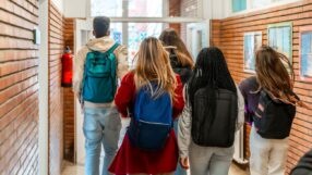 High school students walking through a school hallway