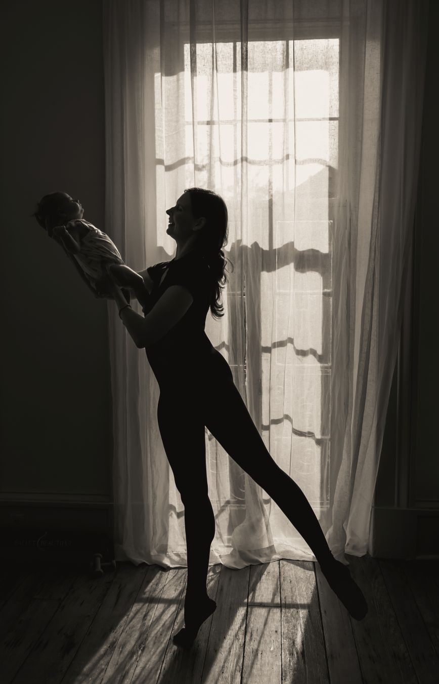 Bowers holding her baby daughter while practicing ballet