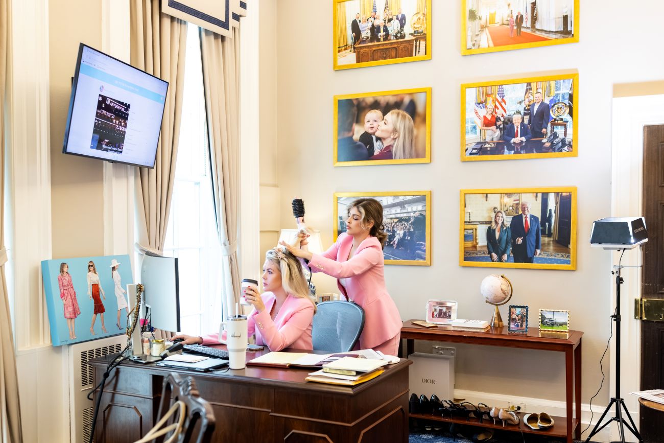Danielle styling Leavitt's hair while Leavitt works on her computer