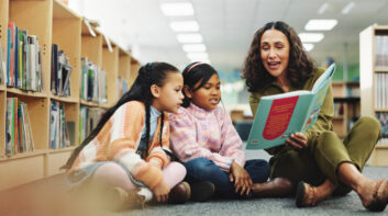 Teacher reading to students in library