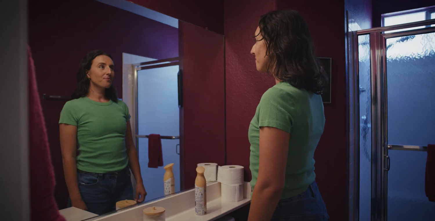Detransitioner Maddie Durbin looking in the mirror