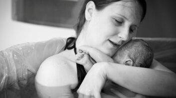 Mother embracing her newborn after home water birth